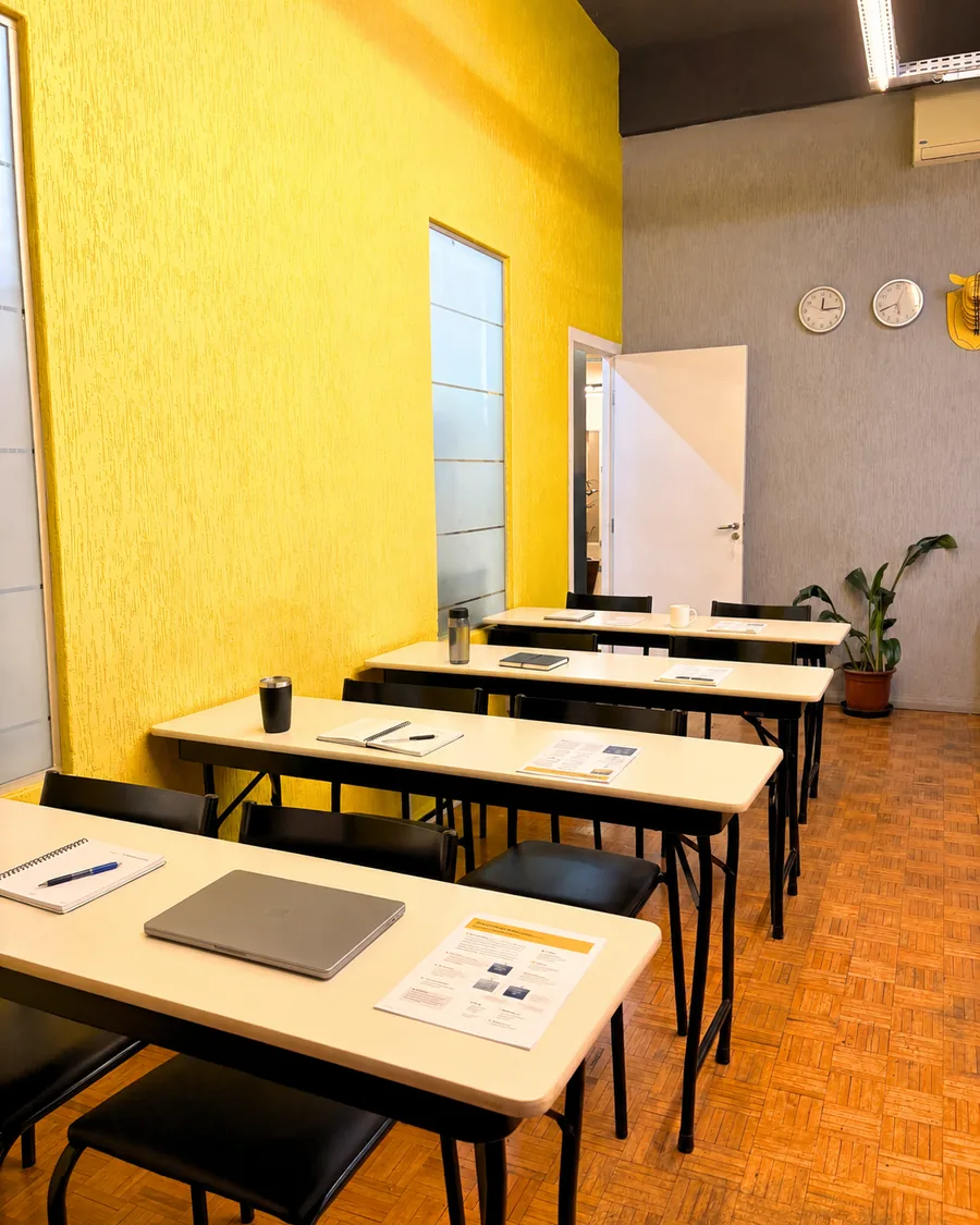 Sala com mesas e cadeiras preparada para trabalho na Aldeia Coworking