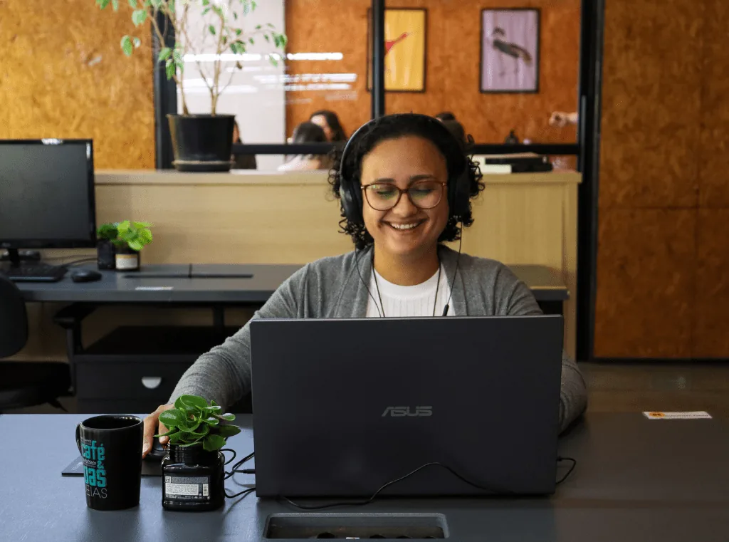 cliente de mesa fixa na Aldeia Coworking sorrindo por estar feliz e satisfeita