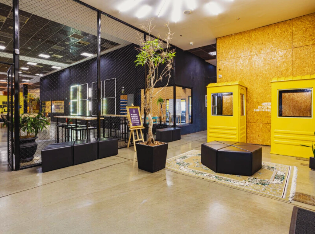 Na Aldeia Coworking em Curitiba, espaço amplo e moderno com detalhes em amarelo, com endereço fiscal curitiba.