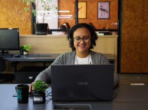 cliente de mesa fixa na Aldeia Coworking sorrindo por estar feliz e satisfeita