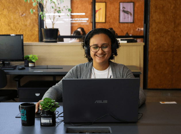 cliente de mesa fixa na Aldeia Coworking sorrindo por estar feliz e satisfeita